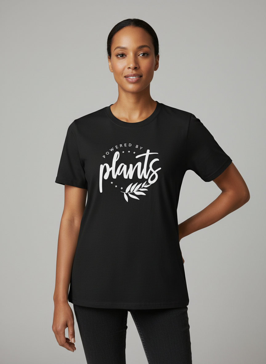 Woman wearing a black t-shirt with 'Powered by plants' text on a gray background vegan